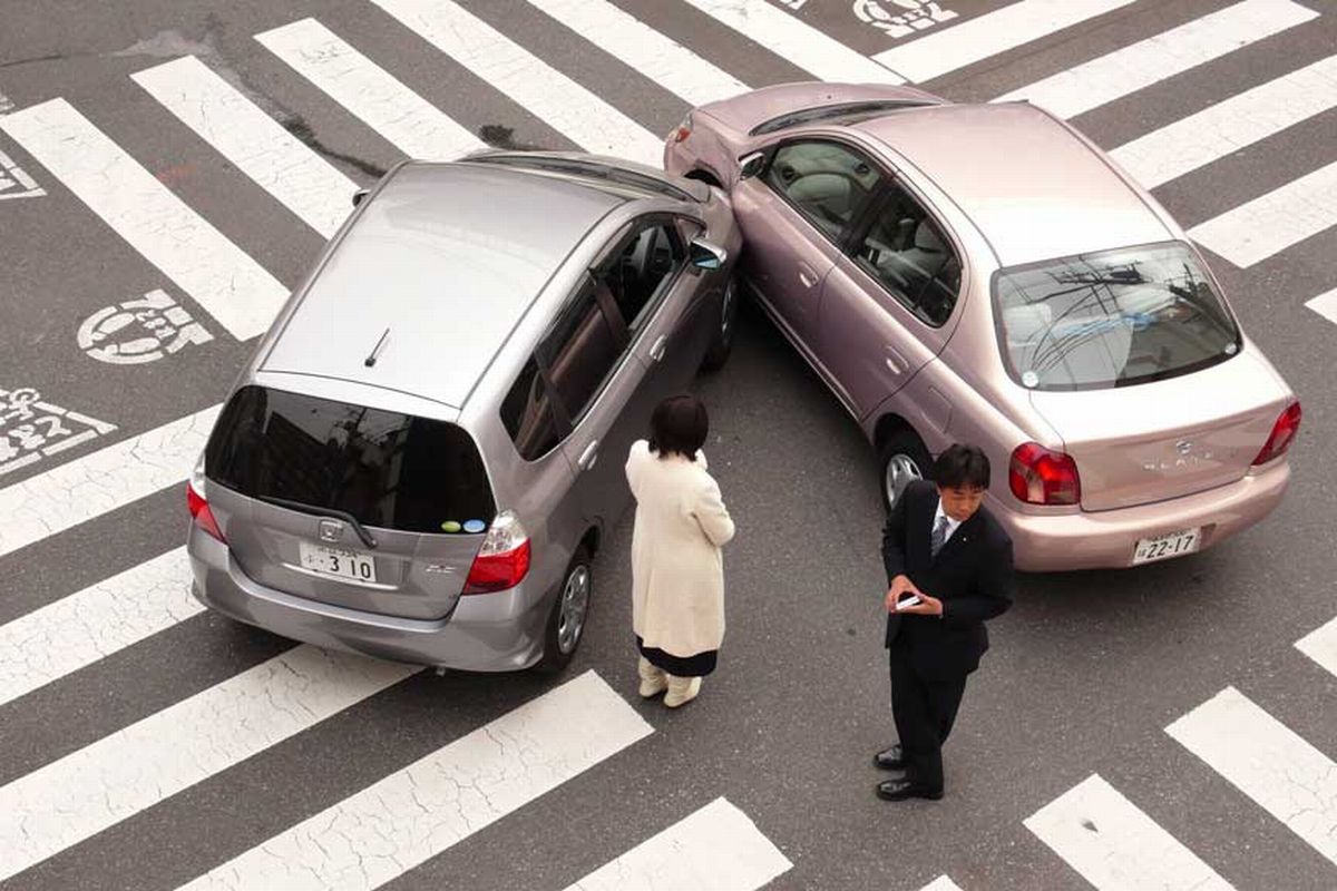 Dois motoristas conversando sobre o seguro de veículos depois de uma batida.