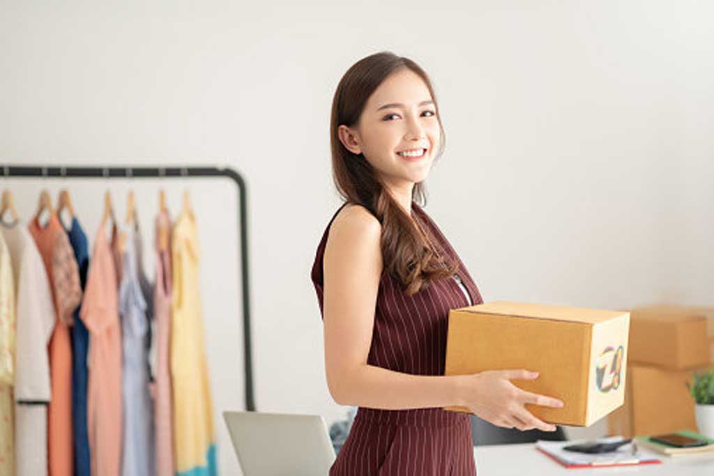 Mulher jovem sorrindo administrando um negócios digital