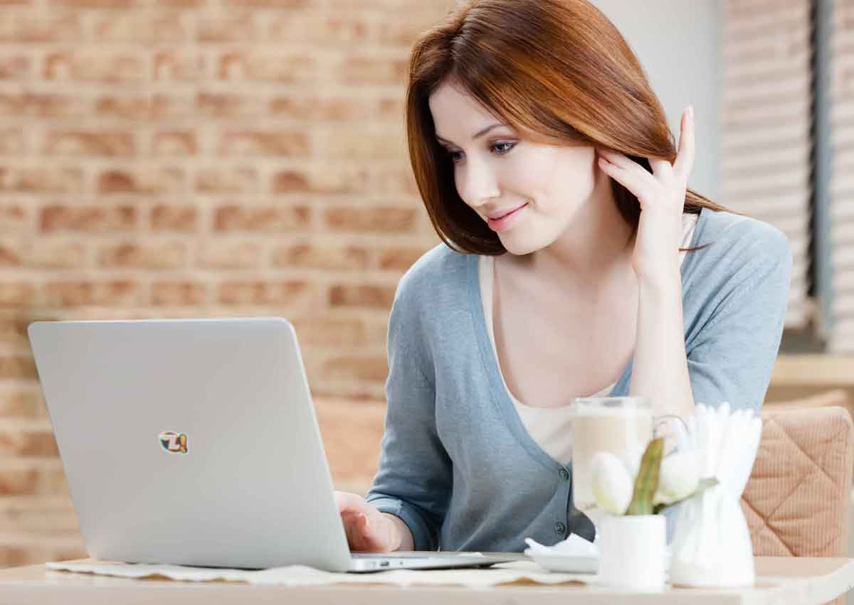 Mulher jovem usando um notebook para pesquisar sobre dinheiro extra.