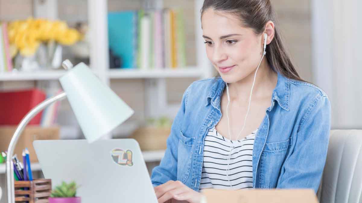 Para Ganhar dinheiro em trabalhando em casa uma mulher morena jovem trabalha pela internet para ganhar dinheiro trabalhando em casa usando um notebook.