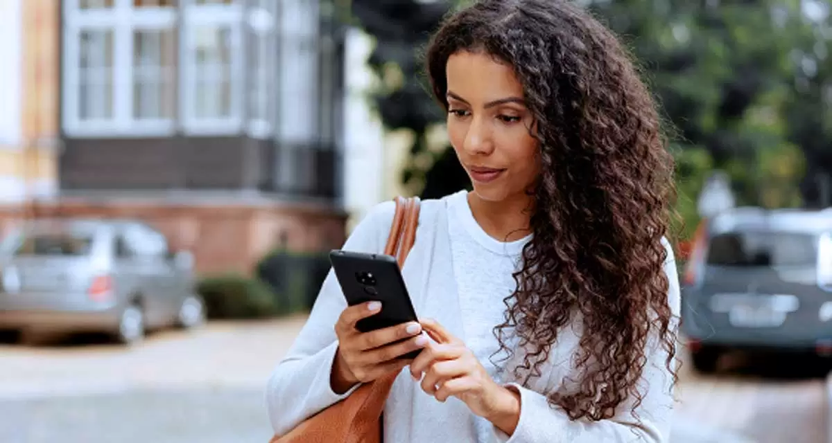 Uma mulher usando um telefone celular.