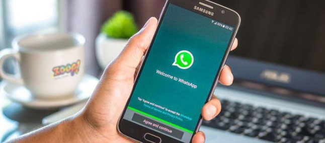 Uma pessoa segurando o smartphone com o whatsapp aberto.